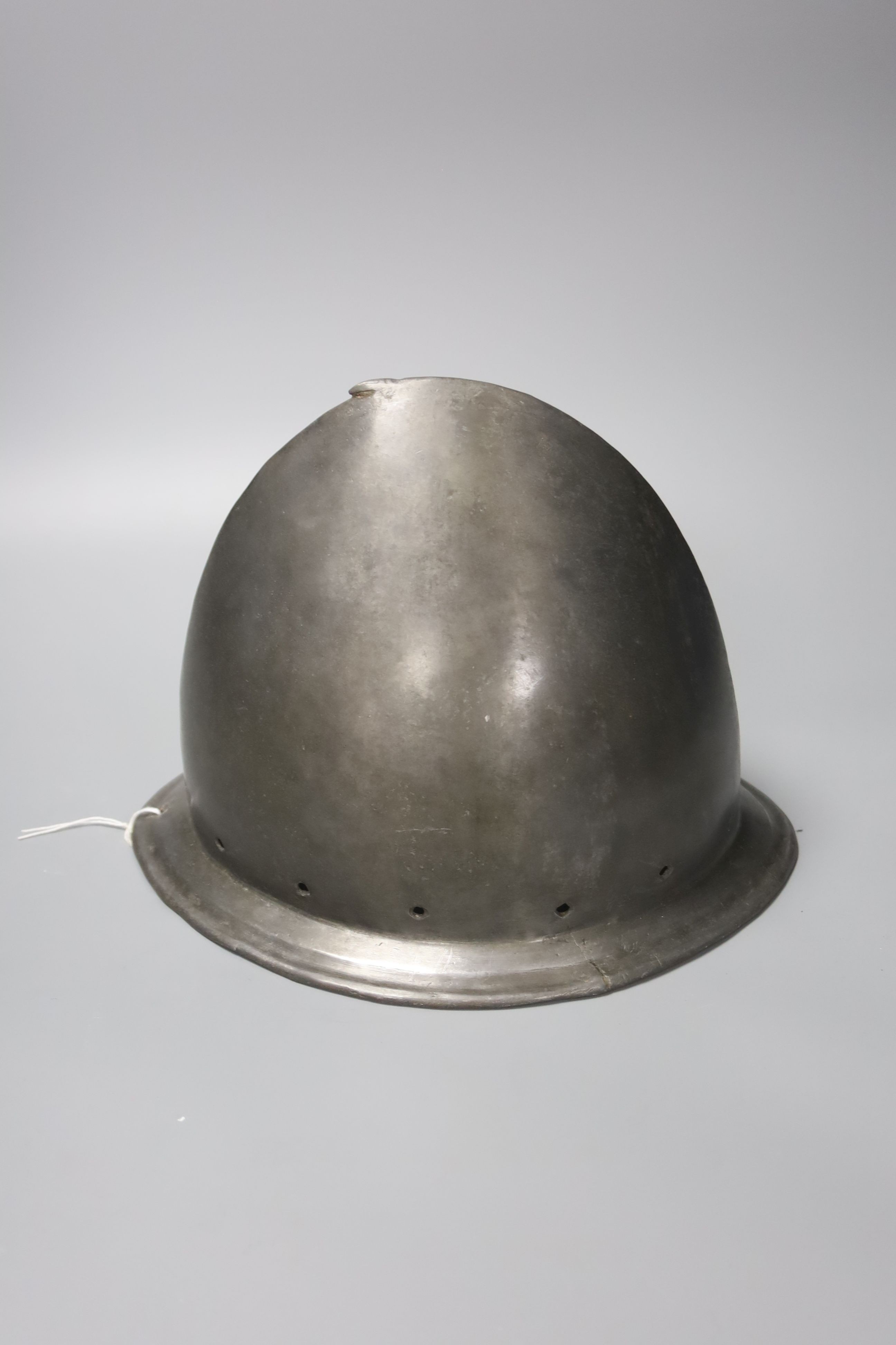 A good Italian Infantry Helmet Cabasset c.1580, polished steel raised from a single plate, medial ridge with pear stalk finial, borders pierced for rosettes, flared brim with turned over edge. Height 20cms.